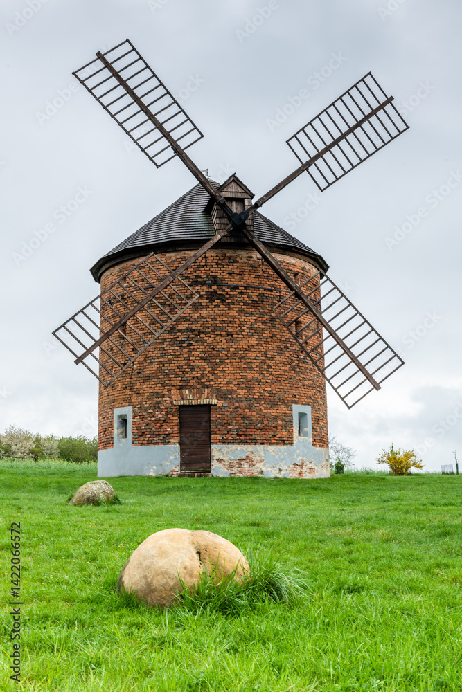 historic windmill in czech village surrounded by spring blossoms