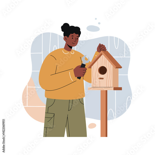 Person assembling wooden birdhouse with screwdriver in cozy indoor setting natural hobbies and leisure activity