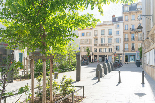 Tableau sur toile Rue Pierre Fourrier in Nancy, France, a peaceful street near the city hall, with trees, bicycles, and light-colored historic buildings bathed in spring sunlight
