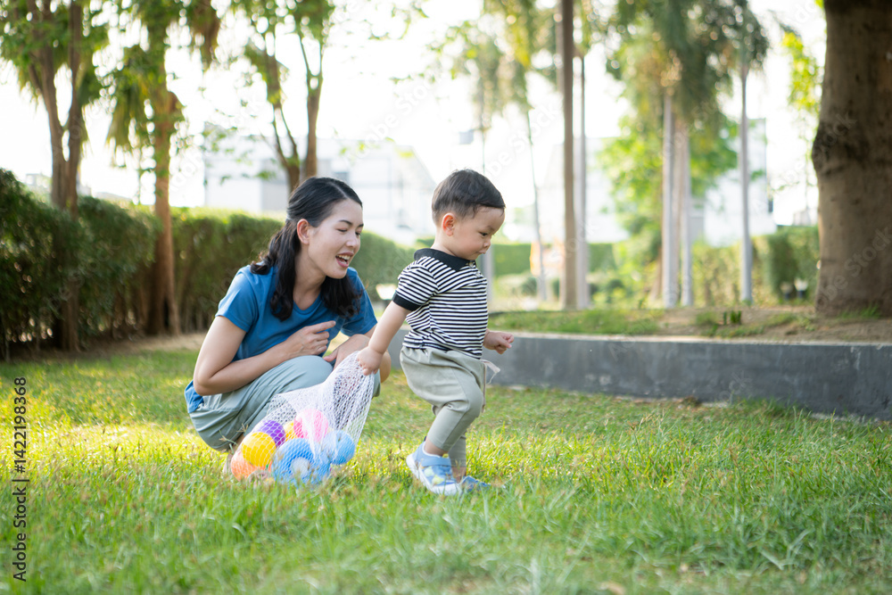 While in vacation at home, a mother engages in activities with little kid in the park While in vacation at home, a mother engages in activities with little kid in the park