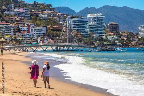 Tableau sur toile Two women walking along the seashore in Puerto Vallarta, Jalisco, Mexico