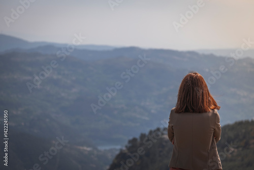 Mulher de costas a olhar para o horizonte nas montanhas