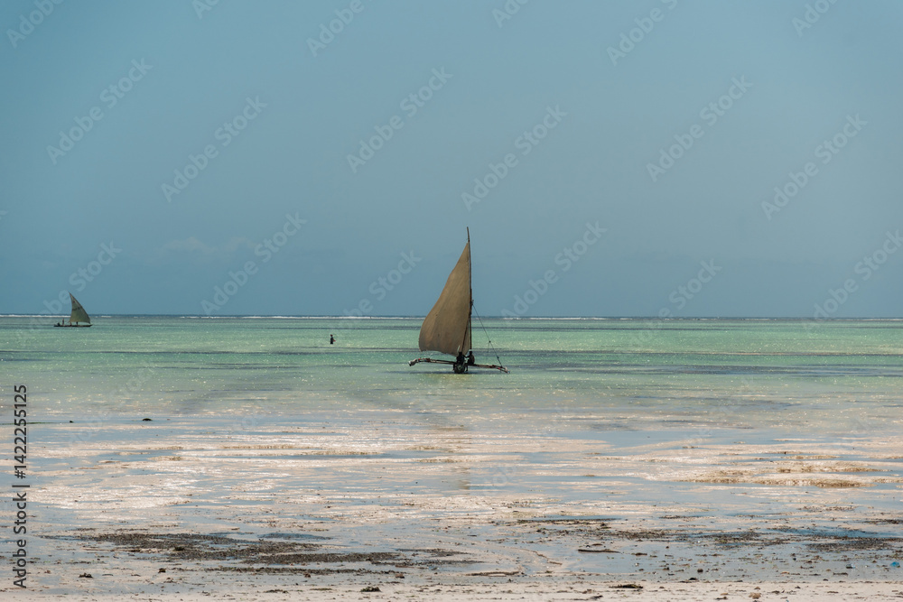 Obraz premium Traditional dhow sailing boats on the turquoise water of zanzibar, tanzania