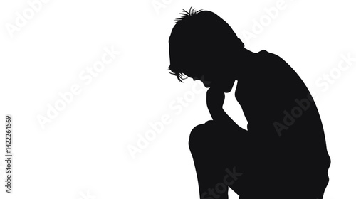 Sad boy sitting alone in silhouette with head resting on hand
