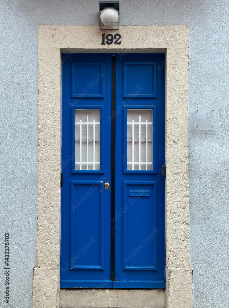 Fototapeta premium Bright blue door with number 192 on a stone frame