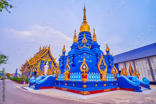 Chedi of Wat Rong Suea Ten in blue color with golden elements, Chiang Rai, Thailan photo
