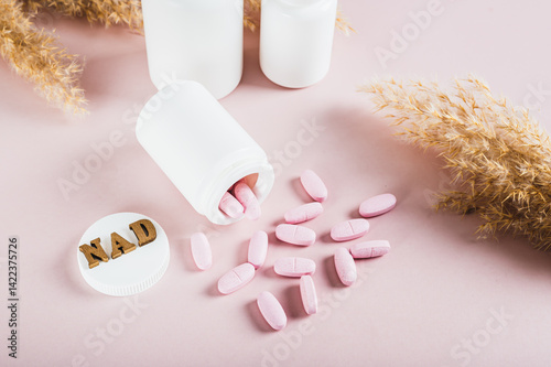 Obraz na płótnie NAD+ molecule in pills for anti-aging and biohacking on pink background w salonie