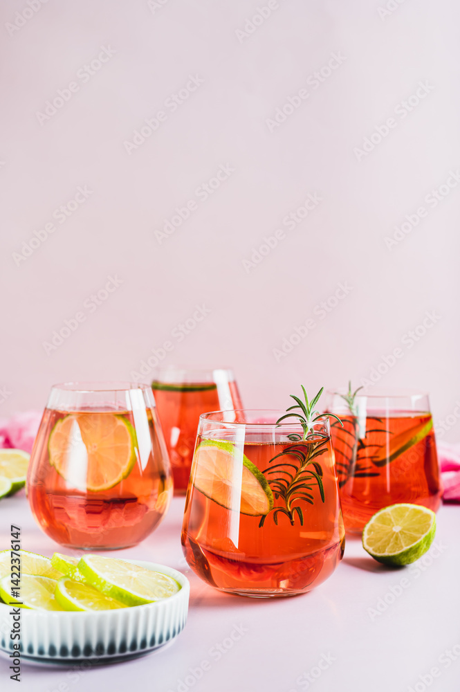 Alcoholic cocktail pink negroni with lime in glasses on table vertical view