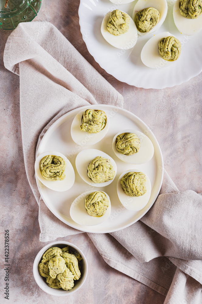 Avocado deviled eggs for appetizer on plate on table top and vertical view