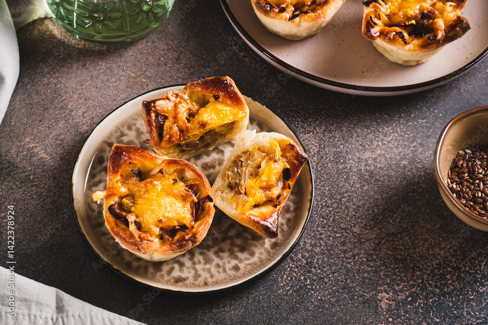 Homemade caramelized onion savory pies on a plate on the table