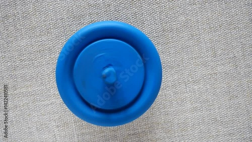 blue wooden spinning top on fabric background
