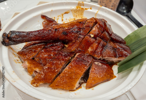 Fotografie A portion of chopped Chinese style roast goose on a plate served with a delicious dark sweet soy sauce