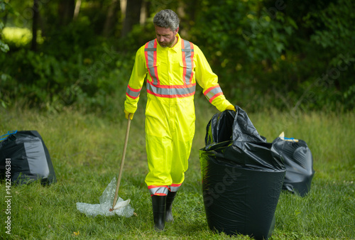 Volunteer in rubber gloves with trash bag clean up garbage on forest outdoor. Eco, environment conservation. Recycle pollution. Man collecting garbage and plastic trash. Save environment.