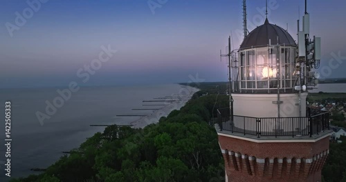 Light beam from lighthouse during sunset at Baltic Sea.