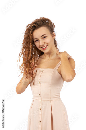 Young beautiful girl in a white dress posing for the camera in the studio on a white background.
