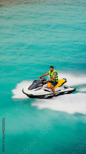 Man riding a jet ski on turquoise water. Wearing life jacket. Fun water sport activity and adventure on vacation. Summer recreation holiday.