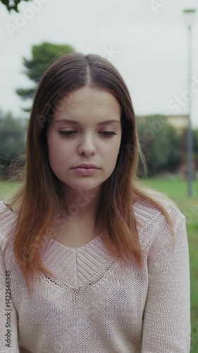 Sad And Lonely Girl Sitting In Park Bench Outdoors During Overcast Day