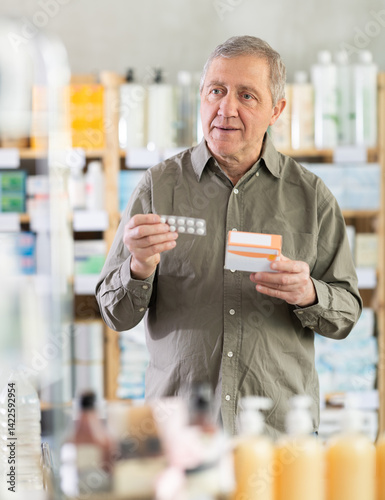 Elderly man from Europe came to the pharmacy and chooses pills. Pensioner buys headache pills