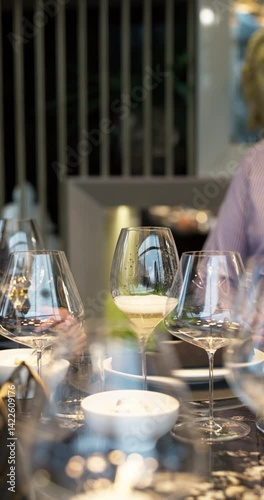 Champagne tasting, Wine glasses are on the table, stylish table setting, wine is poured from a bottle and decanter, sparkling wine bubbles, snacks, people smell the aroma and taste the wine