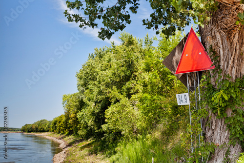 red navigational sign and mileage on left shore of Missouri River