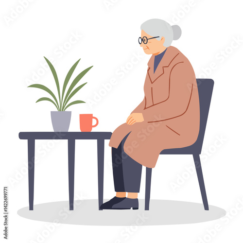Elderly woman sitting in coat indoors - senior woman in coat seated by window with tea cup.