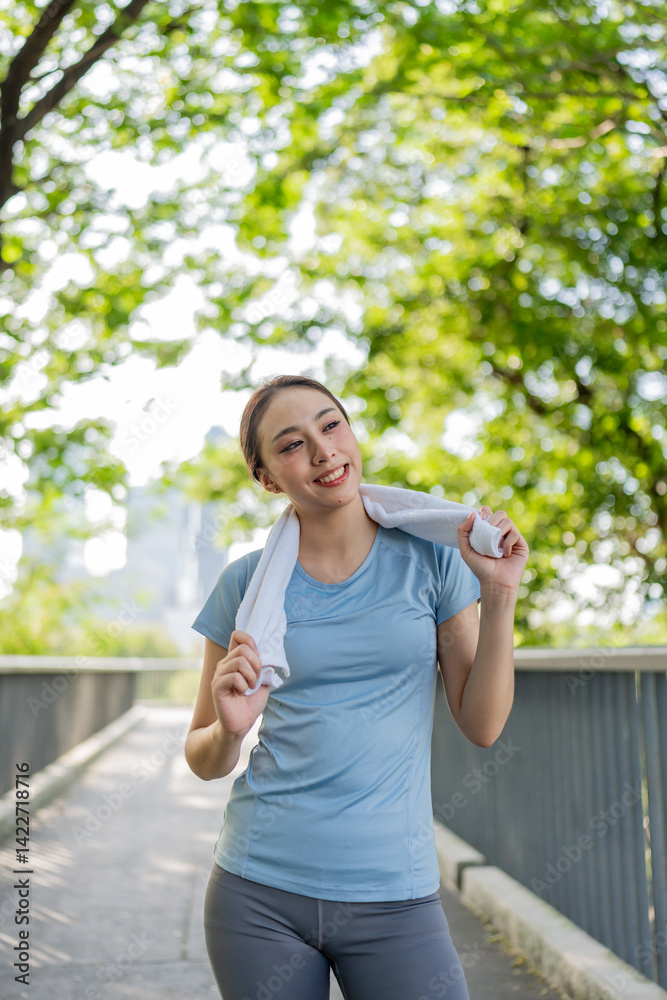 Asian young sportswoman taking a break while exercise outdoors in park. Asian young sportswoman taking a break while exercise outdoors in park.