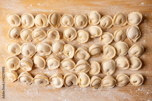 Raw dumplings in flour on the table. Russian national food. Shot from above.