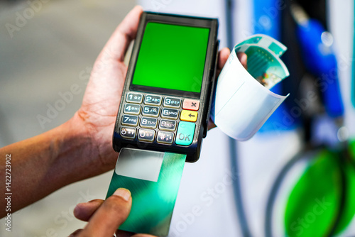 Photo of a gas station employee using a Mobile EDC machine to swipe membership cards and credit cards at a gas station, Thailand.