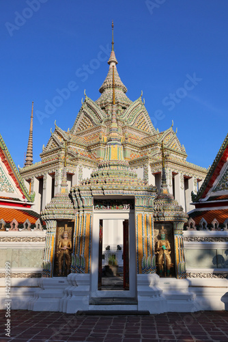 Ornate Thai Buddhist Temple with Detailed Architecture Against Clear Blue Sky