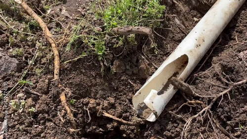 Camera pans to broken dug up gutter near residential home - Contractor work