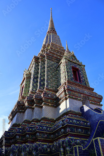 Majestic Thai Pagoda Spire with Intricate Mosaic Tiles Against Clear Blue Sky