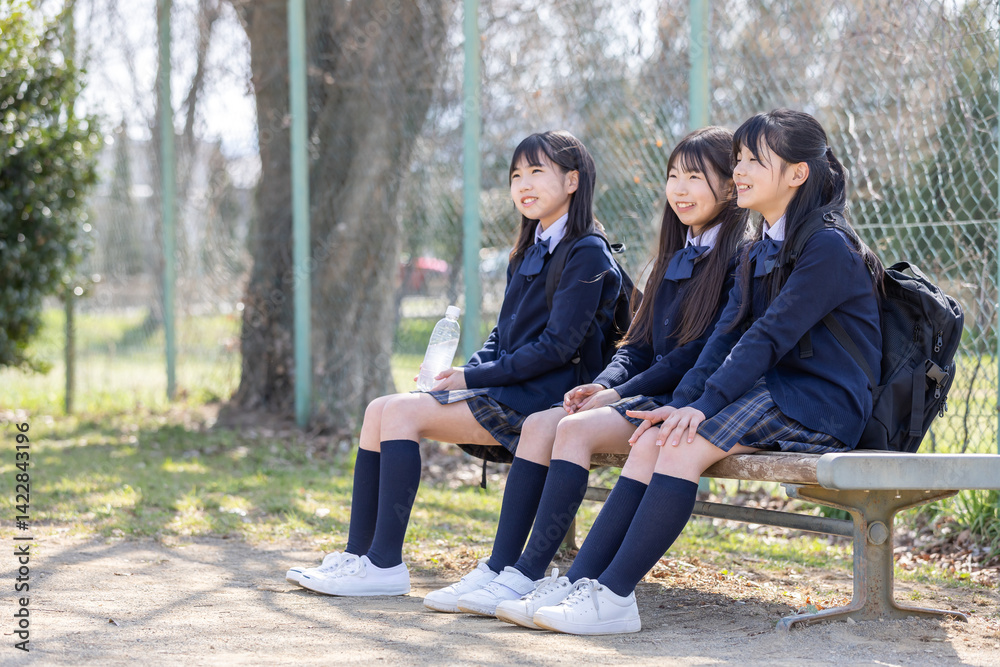 公園のベンチに座る女子学生
