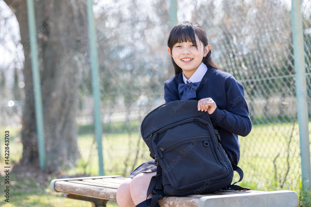 公園のベンチに座る女子学生