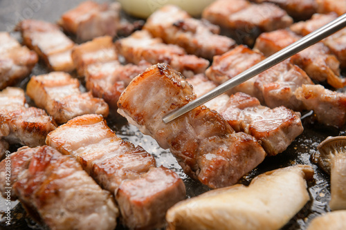 Pork grilling on a black grill
