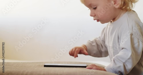 Small Baby pressing and  scrolling with finger on phone touch screen.  Little child  tapping on mobile phone screen. Little child learns to use new  internet technologies, close-up and soft focus
