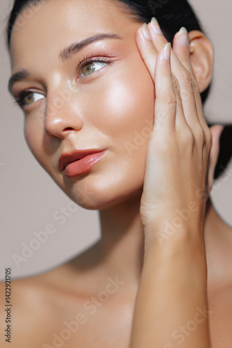 Obraz na plátně Closeup of a Latina woman with flawless, glowing skin gently touching her face