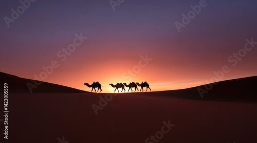 Silhouette of camels in desert sunset