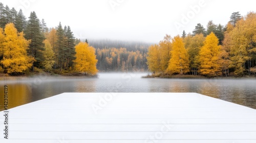 A clean white wooden dock extends towards a calm, misty lake surrounded by vibrant autumn forest foliage.