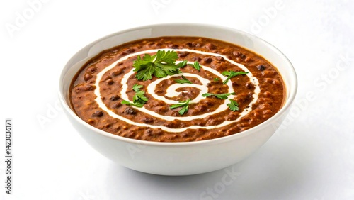 Indian dal makhani in white bowl garnished with cream and coriander isolated on white background
