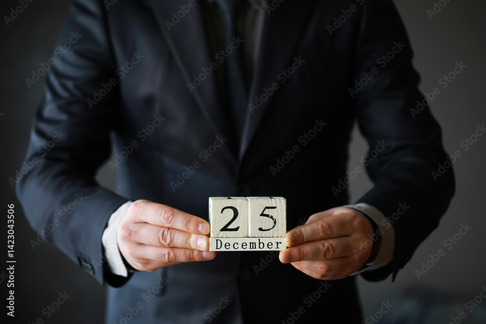 Portrait of businessman ready for Christmas. Wooden cubes with inscription 25 december Portrait of businessman ready for Christmas. Wooden cubes with inscription 25 december
