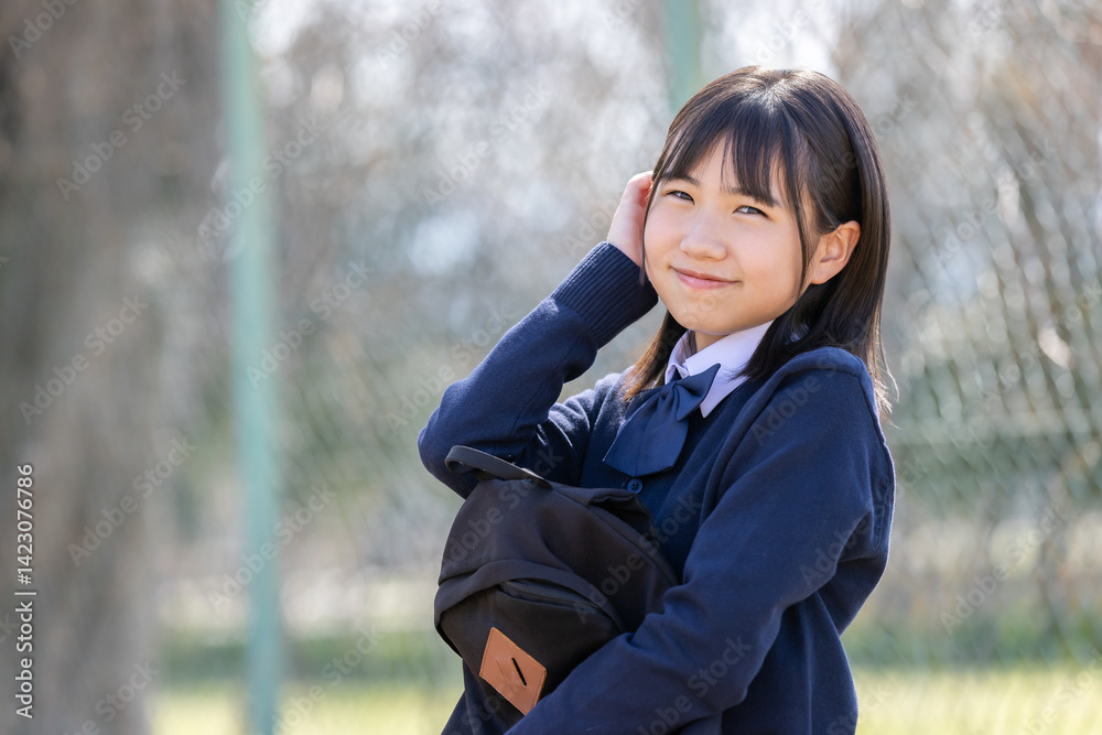 ベンチに座る制服を着た女子学生