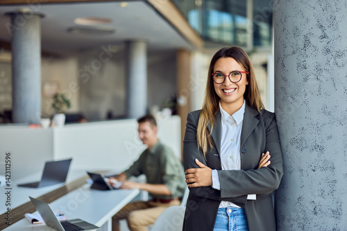 Confident Businesswoman Smiling in Modern Office Environment with Colleagues Working Nearby Free Download Confident Businesswoman Smiling in Modern Office Environment with Colleagues Working Nearby - GFXLoad