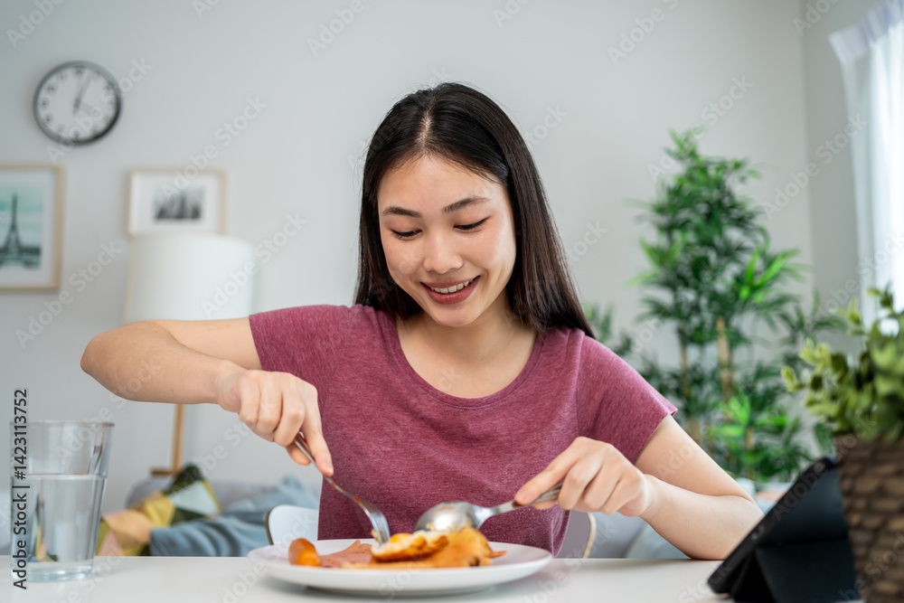 Asian young woman eating American Breakfast in living room at home. Asian young woman eating American Breakfast in living room at home.