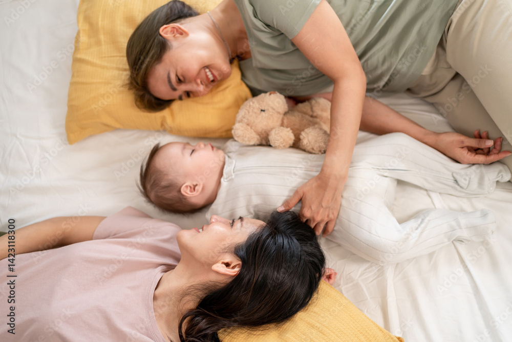 Asian lesbian couple lovingly caring for and raising their baby boy at home. Asian lesbian couple lovingly caring for and raising their baby boy at home.