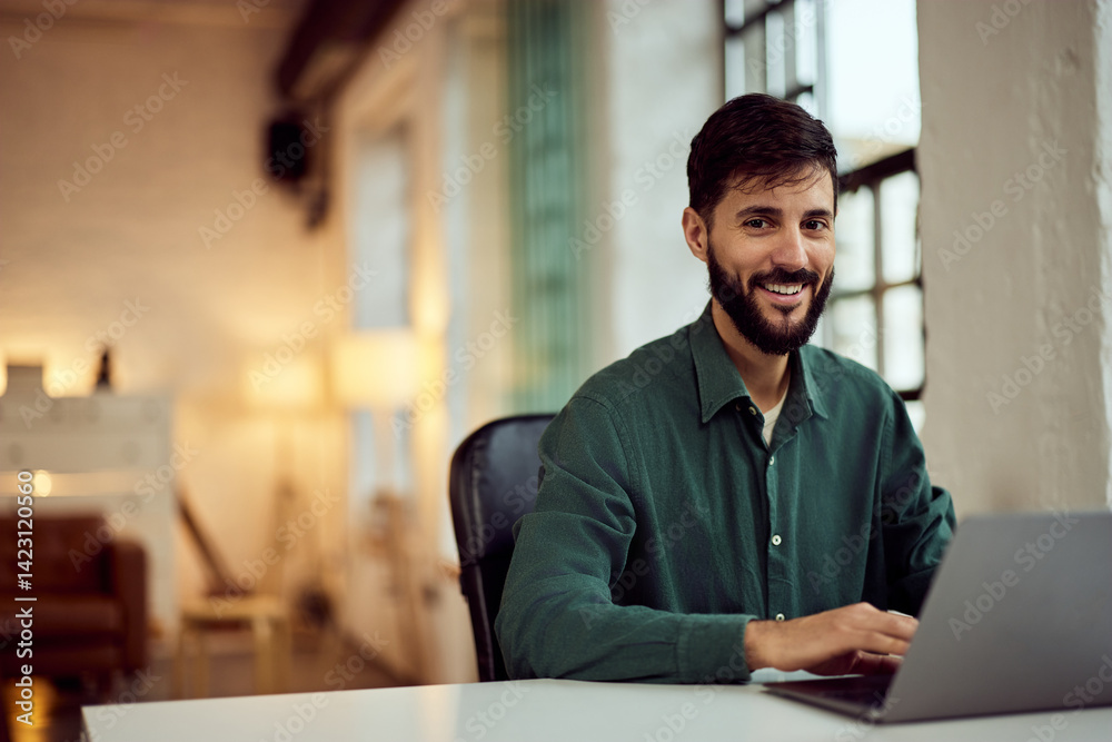 Fototapeta premium Smiling Professional Man in a Modern Office Working on a Laptop