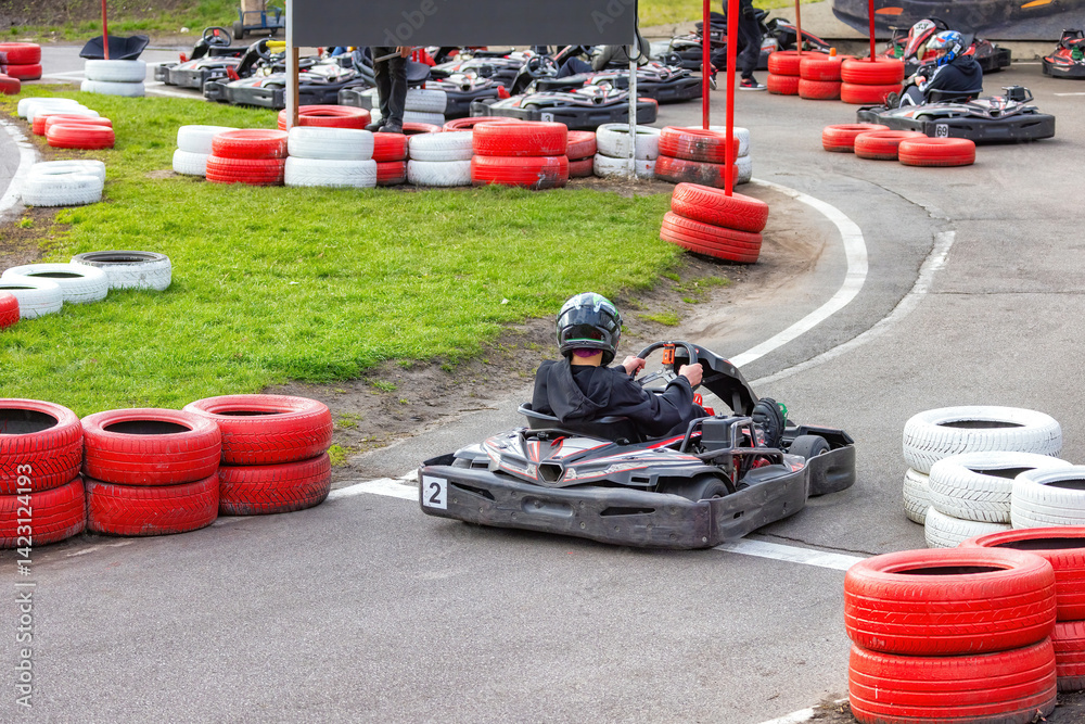 Exciting kart racing action at a colorful outdoor track on a sunny day.