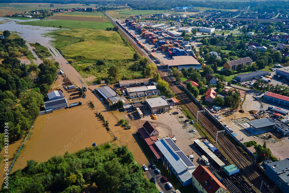 Aerial view of flooded streets, railway tracks and buildings in a suburban area. Industrial zone with floodwater after heavy rain. Concept of natural disaster, climate impact and emergency