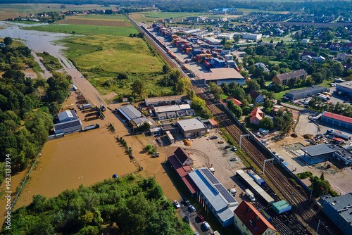 Obraz na płótnie Aerial view of flooded streets, railway tracks and buildings in a suburban area. Industrial zone with floodwater after heavy rain. Concept of natural disaster, climate impact and emergency w salonie