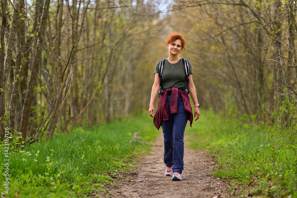 Fototapeta premium Woman hiking on forest path