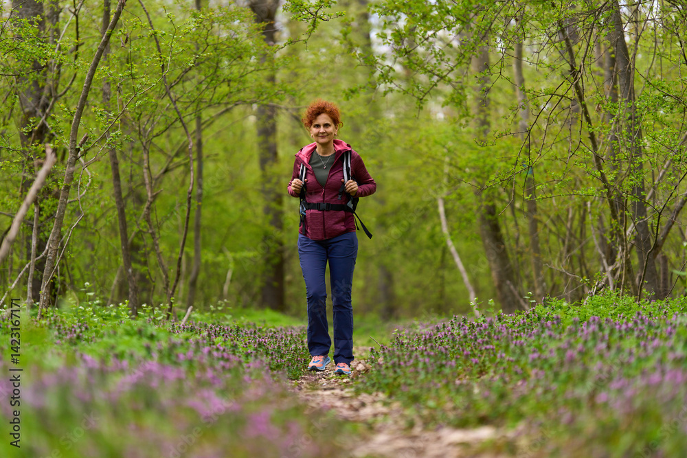 Woman hiking on forest path Woman hiking on forest path